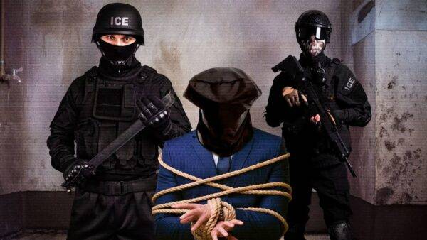 Man in blue suit bound, masked, ICE agents looming